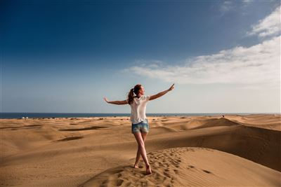 Frau spaziert auf den Dünen Maspalomas
